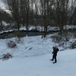 Žena sa fotoaparatom uz rijeku