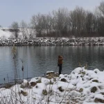 Žena sa fotoaparatom uz rijeku