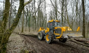 Bager vuče stabla u šumi
